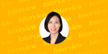 This image shows a professional portrait of Hyungyu Kang, Partner at Yulchon LLC, set against a bright yellow background with repeated “Interview” text in the backdrop, emphasizing the focus on her featured interview.