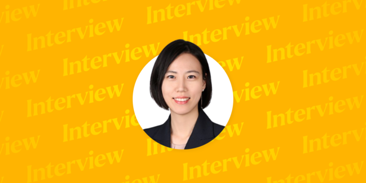 This image shows a professional portrait of Hyungyu Kang, Partner at Yulchon LLC, set against a bright yellow background with repeated “Interview” text in the backdrop, emphasizing the focus on her featured interview.